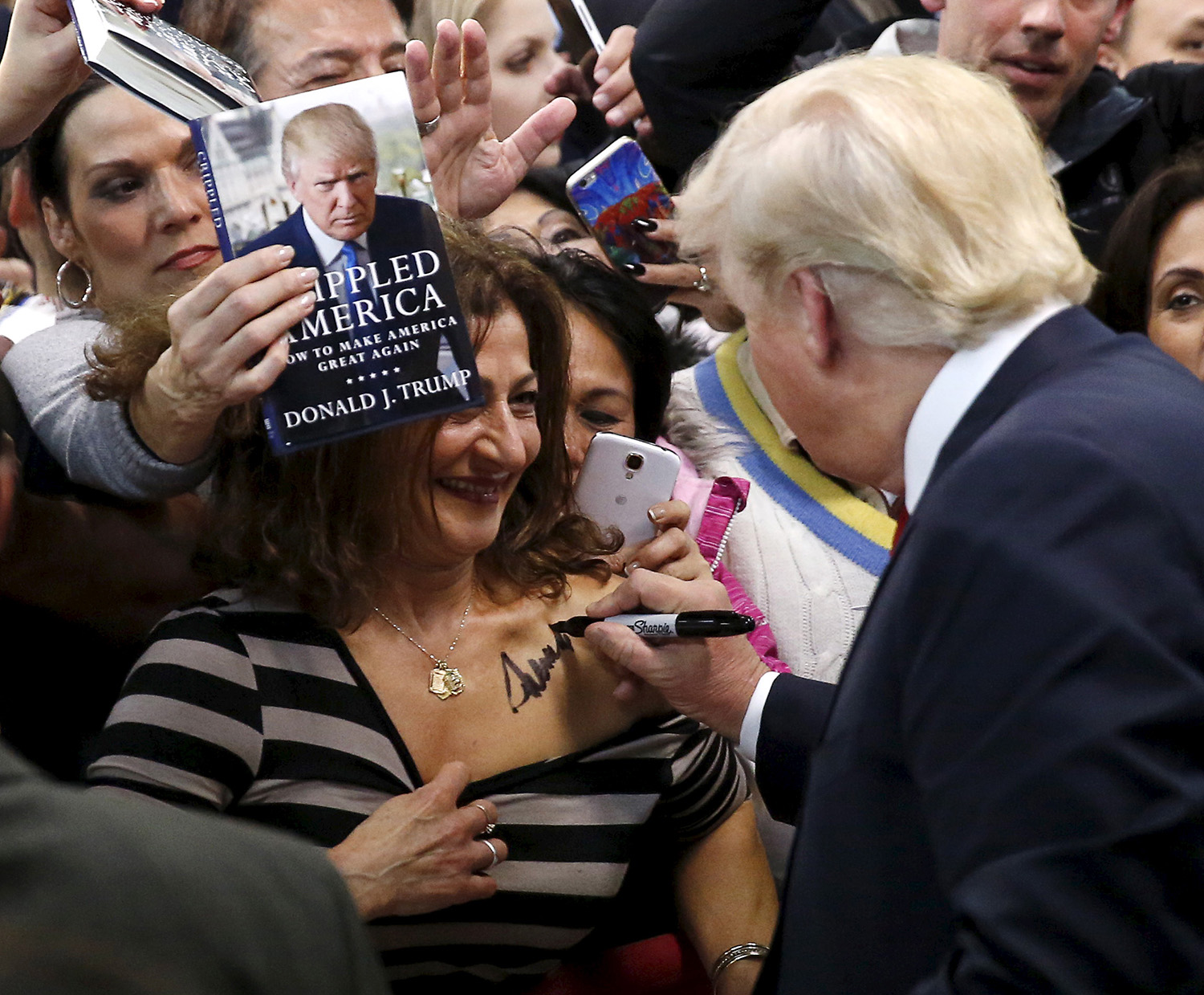 Republican presidential candidate Trump autographs chest of woman at his campaign rally in Manassas, Virginia