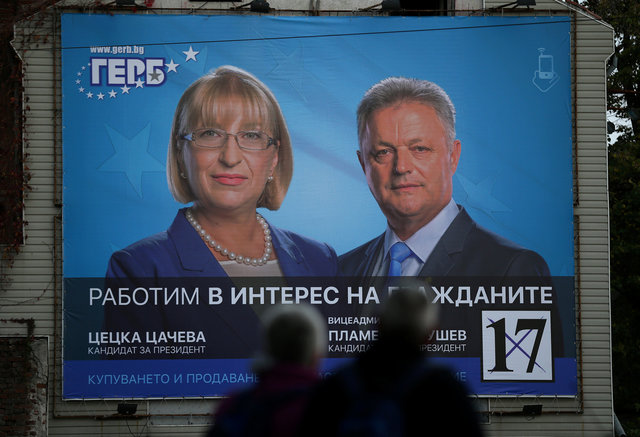 People walk near election poster of the presidential candidate of the Bulgaria's ruling centre-right GERB party, Tsacheva in Plovdiv